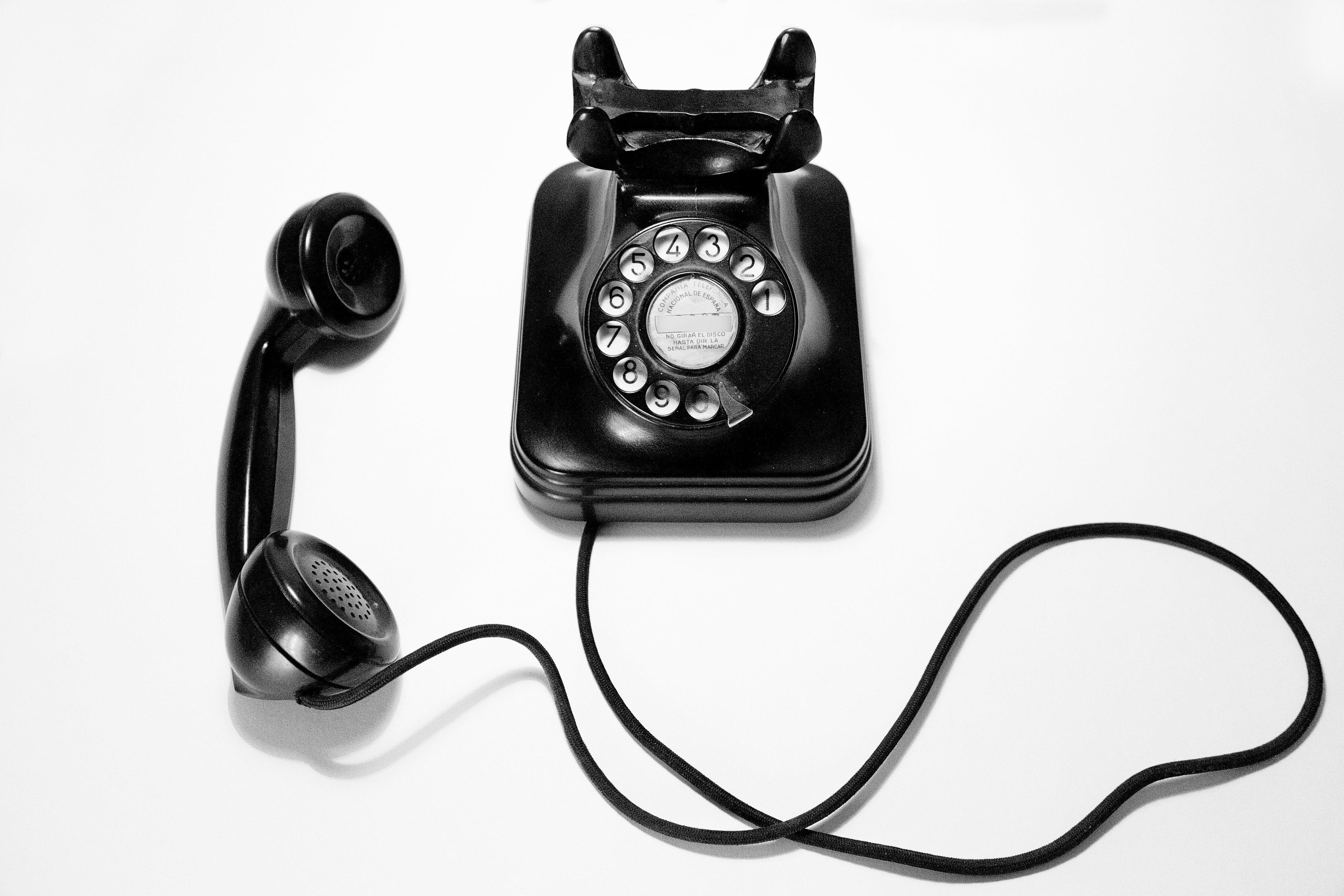Vintage black rotary phone on a white background